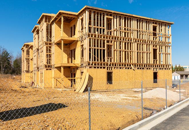 a close-up of temporary chain link fences enclosing a job site, signaling progress in the project's development in Goleta